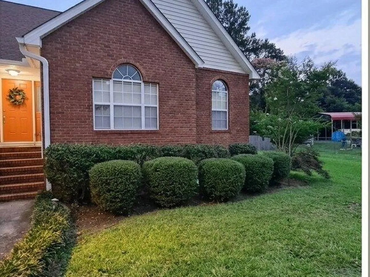 Brick ranch front bed, overgrown shrubs cut back and shaped, after