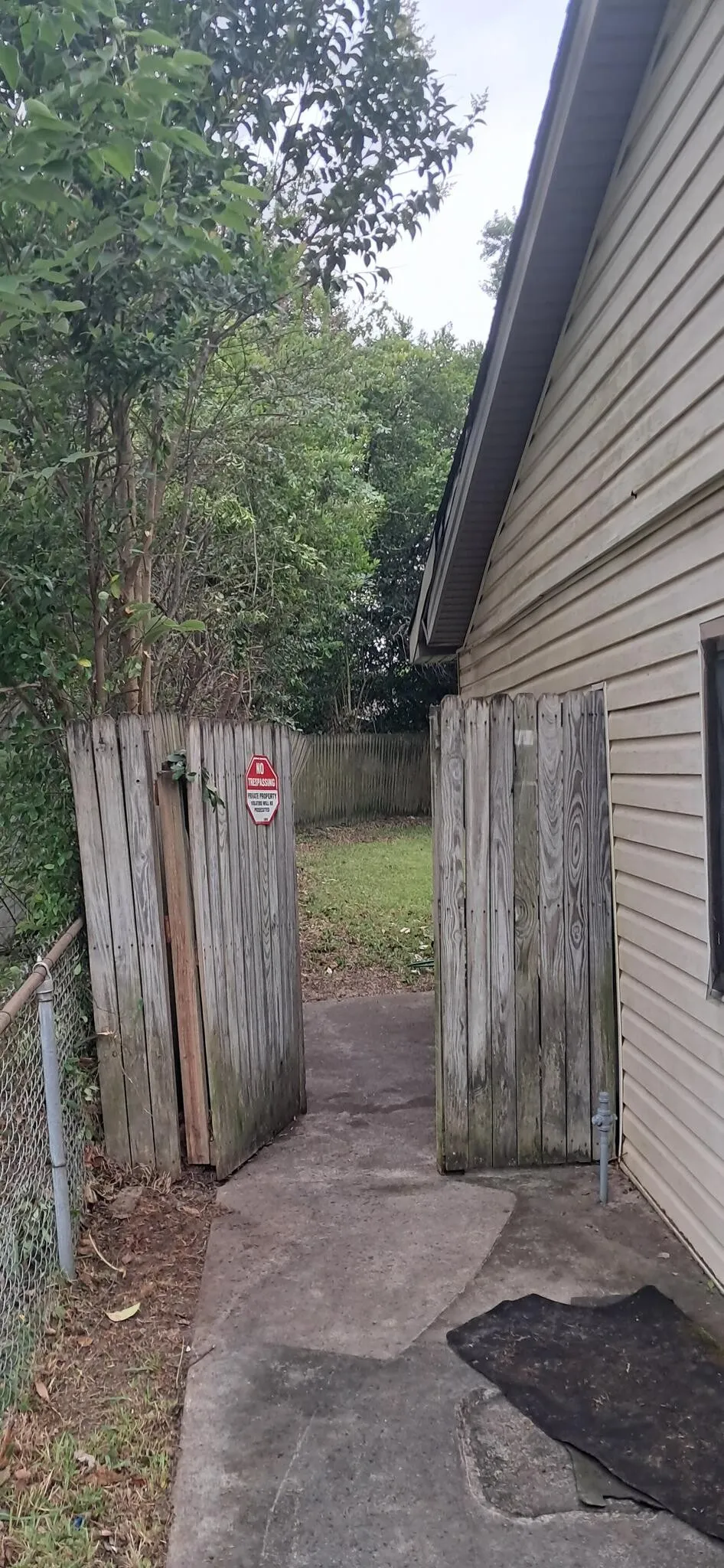 Narrow side yard cleared between fence and house